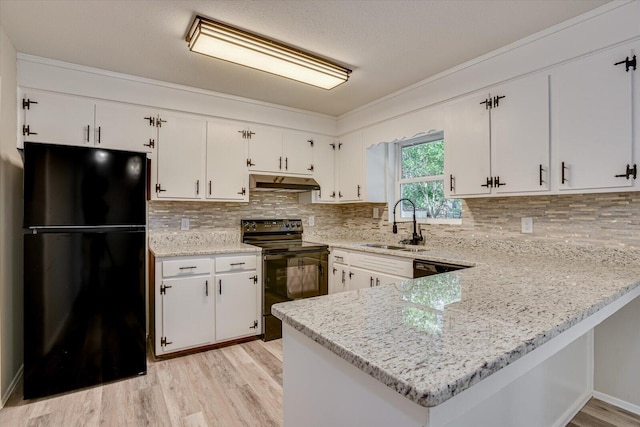 kitchen with black appliances, light stone counters, white cabinets, and sink