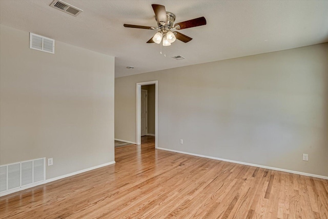 empty room with ceiling fan and light hardwood / wood-style flooring