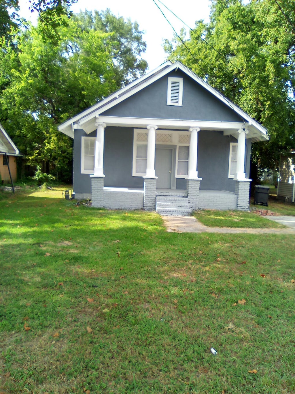 view of front of house with a front yard and a porch