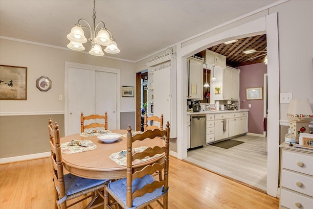 889 Woodhaven St, North, SC 29112 - dining area with light wood-style flooring, a chandelier, arched walkways, and ornamental molding