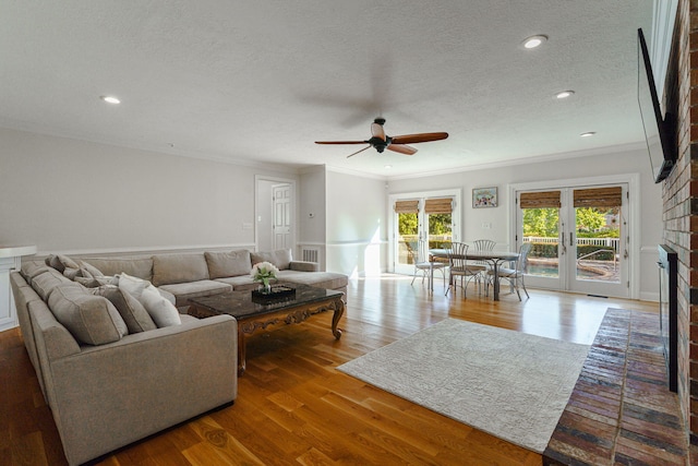 3507 Lost Tree Ln, Martinez, GA 30907 - living room with a brick fireplace, ornamental molding, ceiling fan, a textured ceiling, and wood finished floors