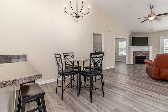 2697 York Dr, Augusta, GA 30909 - dining area with wood finished floors, ceiling fan, vaulted ceiling, a stone fireplace, and baseboards