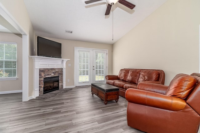 2697 York Dr, Augusta, GA 30909 - living area featuring wood finished floors, ceiling fan, a stone fireplace, lofted ceiling, and baseboards