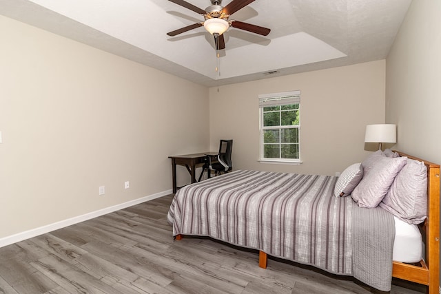 2697 York Dr, Augusta, GA 30909 - bedroom featuring wood finished floors, a tray ceiling, baseboards, and ceiling fan