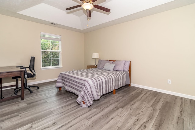 2697 York Dr, Augusta, GA 30909 - bedroom with wood finished floors, baseboards, a tray ceiling, and ceiling fan
