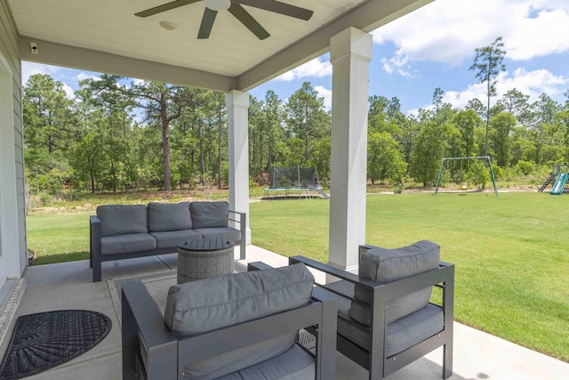 view of patio featuring a trampoline, an outdoor living space, a playground, ceiling fan, and view of wooded area
