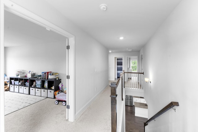 corridor featuring an upstairs landing, attic access, and baseboards