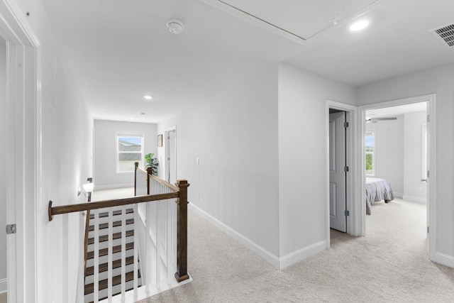 hallway with an upstairs landing, attic access, carpet, baseboards, and recessed lighting
