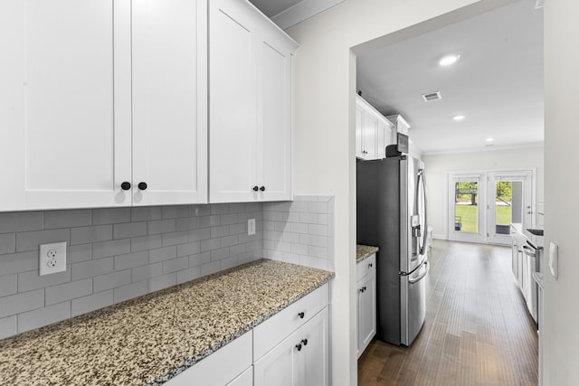 kitchen featuring stainless steel refrigerator with ice dispenser, light stone countertops, white cabinets, dark wood-type flooring, and recessed lighting
