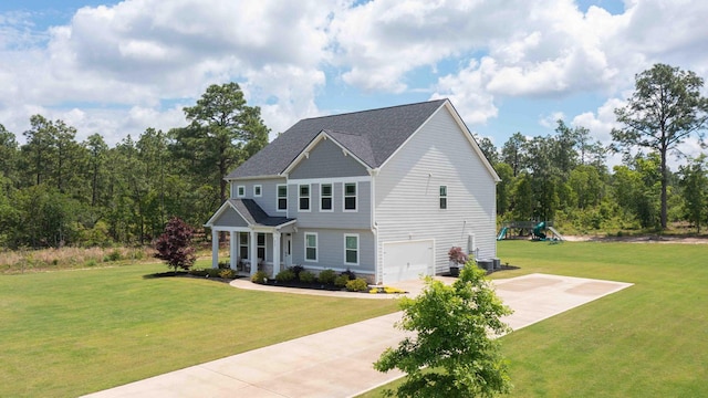 craftsman inspired home featuring an attached garage, a front lawn, concrete driveway, and a playground