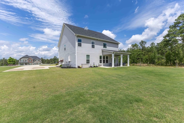 rear view of house featuring a yard and a patio
