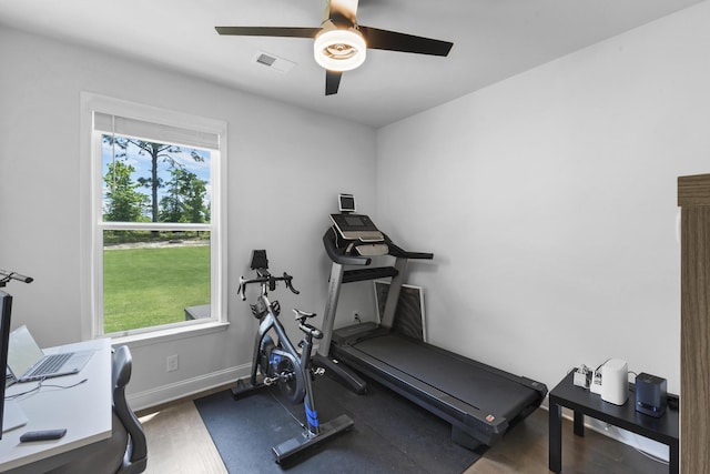 workout room with a ceiling fan, baseboards, and wood finished floors
