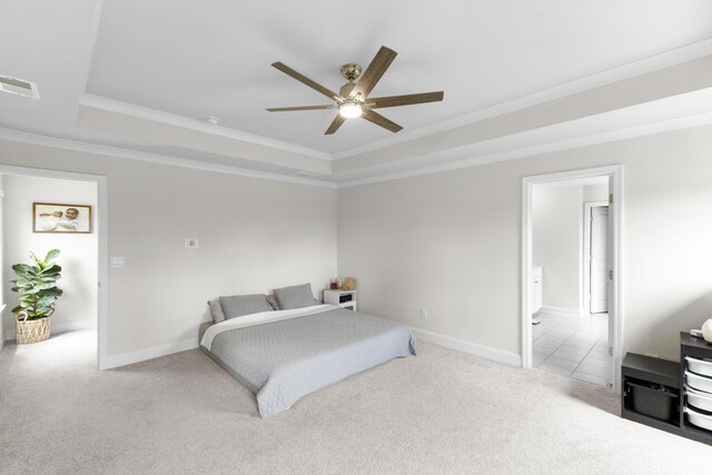 bedroom featuring a tray ceiling, carpet floors, ornamental molding, baseboards, and a ceiling fan