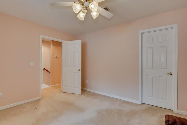 unfurnished bedroom with ceiling fan and light colored carpet