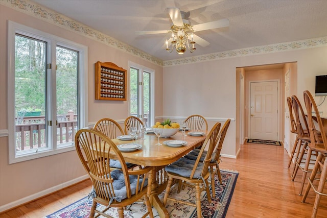 dining space with light hardwood / wood-style floors and ceiling fan