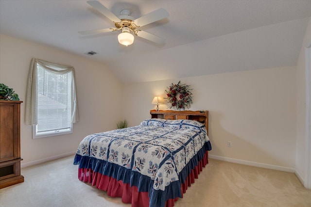 carpeted bedroom with ceiling fan and vaulted ceiling