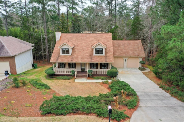 cape cod-style house featuring central AC, a garage, covered porch, and a front lawn