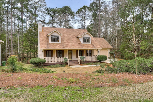 cape cod home featuring covered porch and a garage