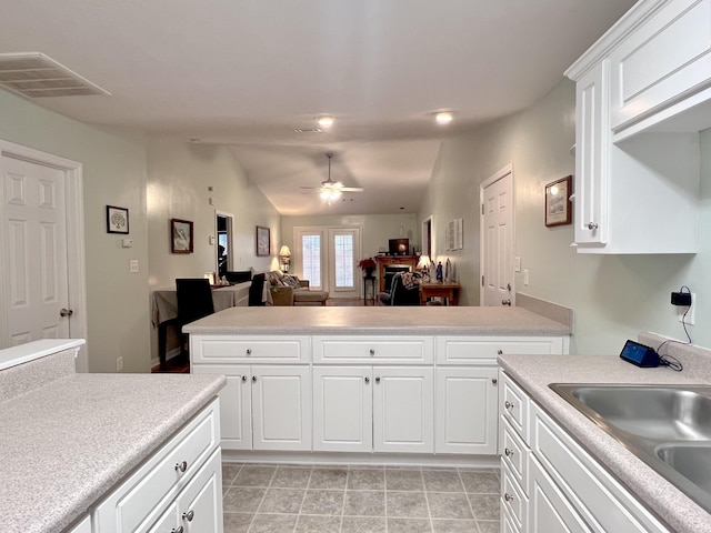 kitchen with ceiling fan, white cabinetry, sink, and vaulted ceiling