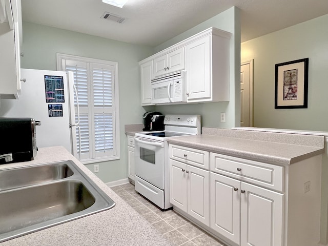 kitchen with white cabinets, white appliances, sink, and light tile patterned floors