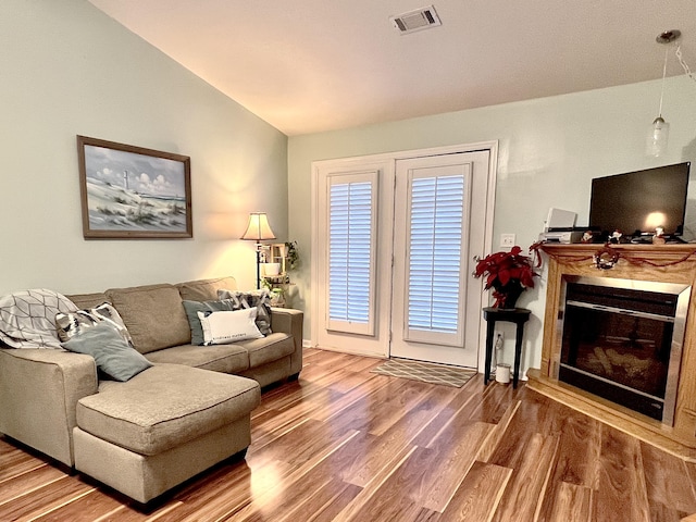 living room with wood-type flooring and vaulted ceiling