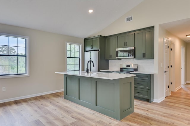 3022 Shady Ln, Hephzibah, GA 30815 - kitchen featuring green cabinets, stainless steel appliances, light countertops, light wood-style floors, and backsplash