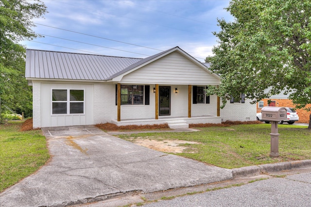 3022 Shady Ln, Hephzibah, GA 30815 - view of front of home featuring covered porch, a front yard, brick siding, board and batten siding, and metal roof