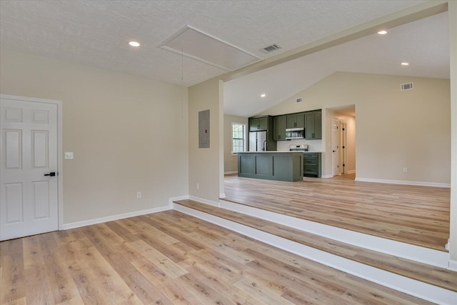3022 Shady Ln, Hephzibah, GA 30815 - unfurnished living room with attic access, light wood finished floors, vaulted ceiling, baseboards, and a textured ceiling