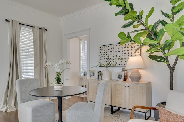 dining room with light wood-type flooring and ornamental molding