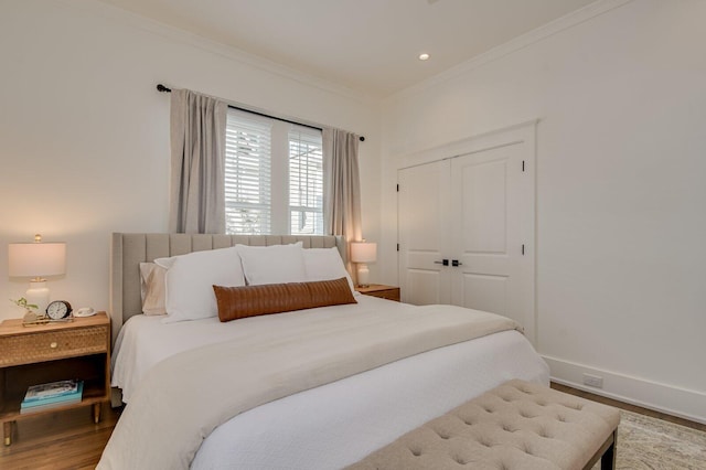 bedroom featuring hardwood / wood-style floors, a closet, and crown molding