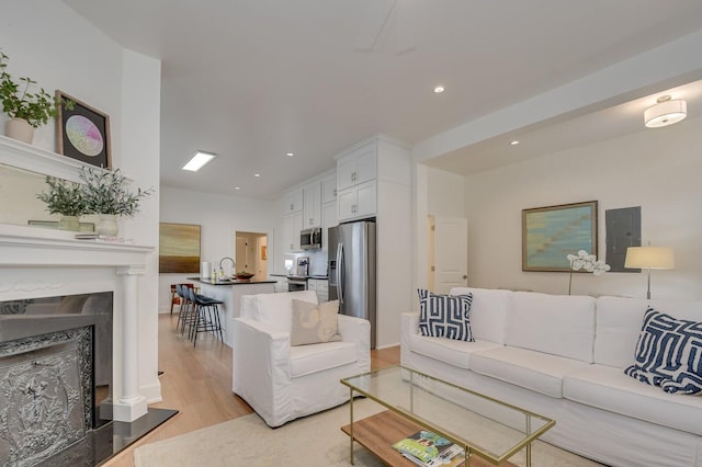 living room with electric panel and light hardwood / wood-style flooring