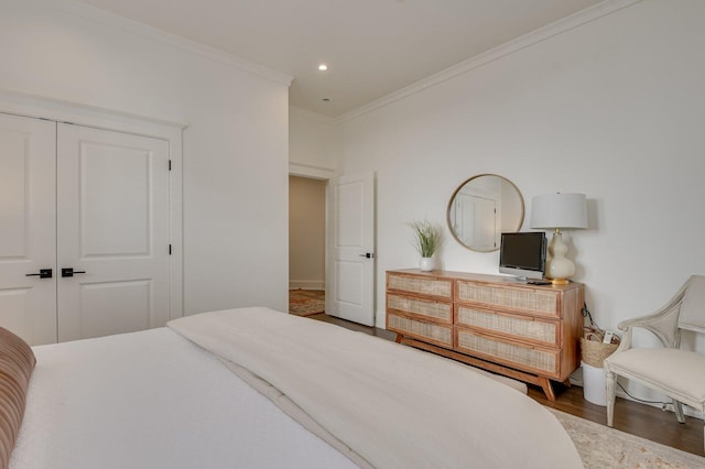 bedroom with dark wood-type flooring, a closet, and crown molding