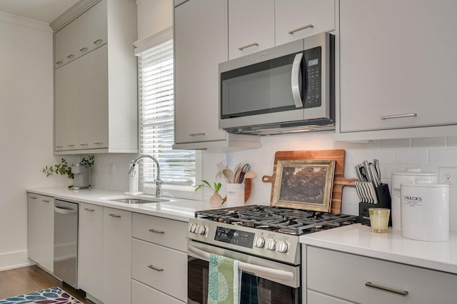 kitchen with backsplash, dark wood-type flooring, sink, and stainless steel appliances