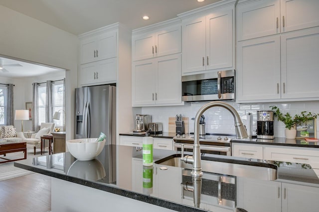 kitchen with backsplash, white cabinetry, ceiling fan, and appliances with stainless steel finishes