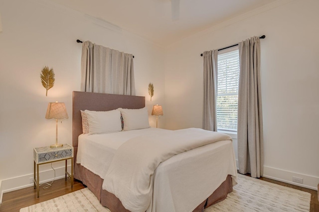 bedroom featuring ceiling fan, hardwood / wood-style floors, and ornamental molding