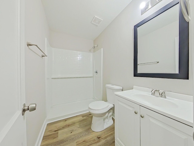 bathroom featuring hardwood / wood-style floors, vanity, toilet, and a shower