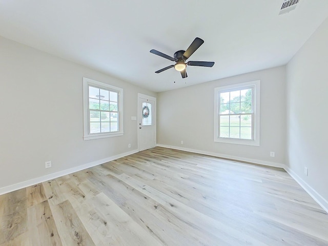 unfurnished room featuring light wood-type flooring, a wealth of natural light, and ceiling fan