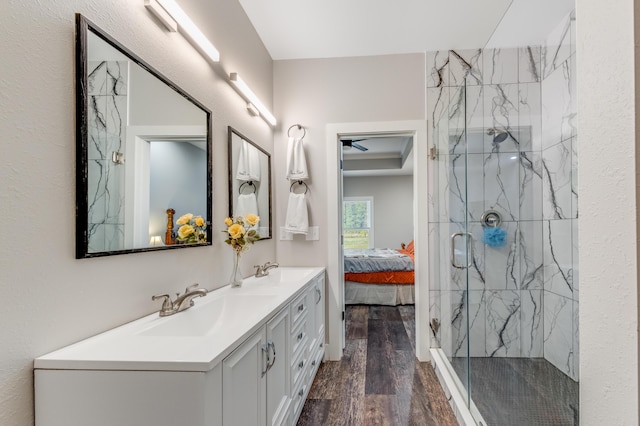 full bath featuring a marble finish shower, ensuite bathroom, wood finished floors, and a sink