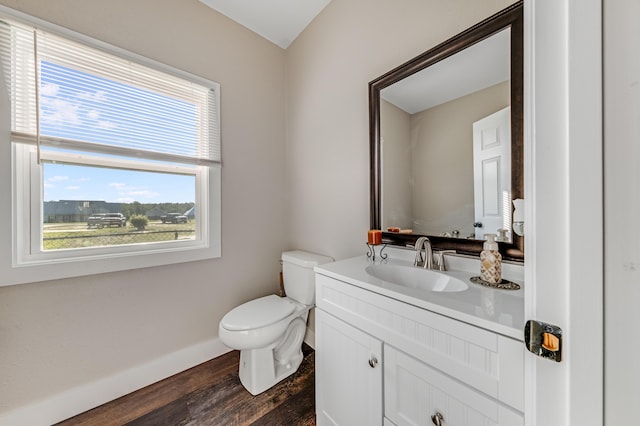 bathroom with vanity, toilet, baseboards, and wood finished floors