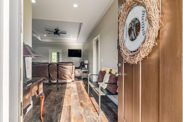 interior space with a tray ceiling, wood finished floors, ceiling fan, and recessed lighting
