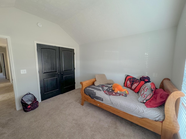 bedroom featuring carpet, a closet, and lofted ceiling