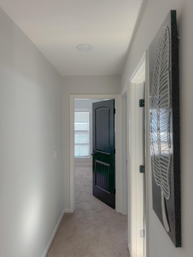 hallway featuring light colored carpet