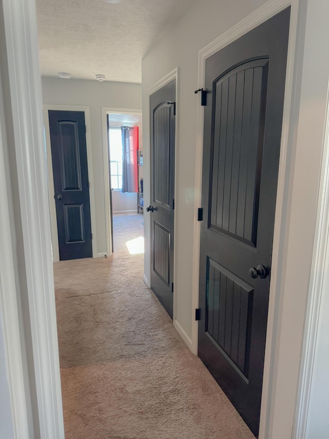 corridor with carpet flooring and a textured ceiling