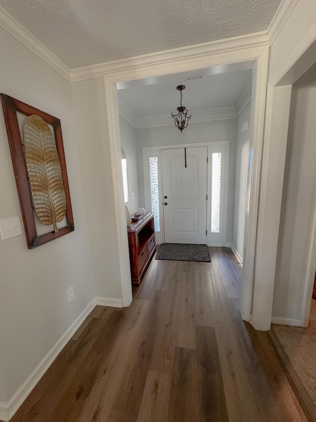 foyer with crown molding, a textured ceiling, and hardwood / wood-style flooring