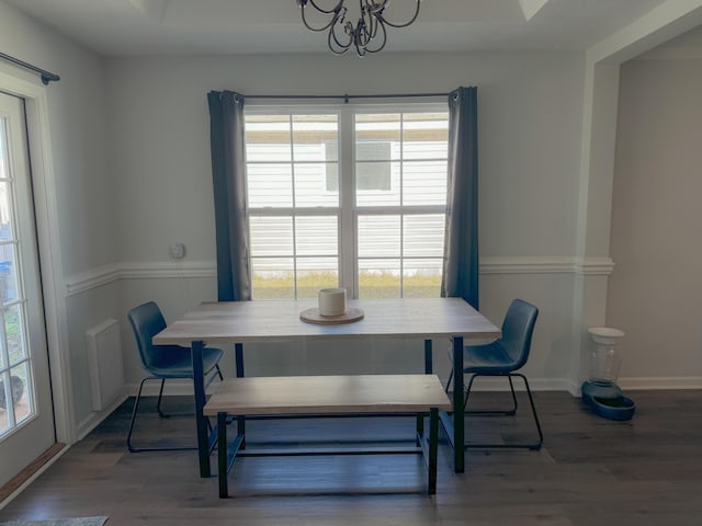 dining room featuring a chandelier, a healthy amount of sunlight, and hardwood / wood-style flooring