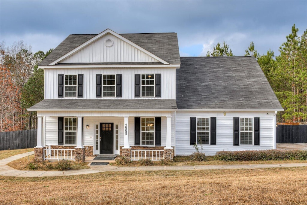 view of front of house with a porch and a front lawn