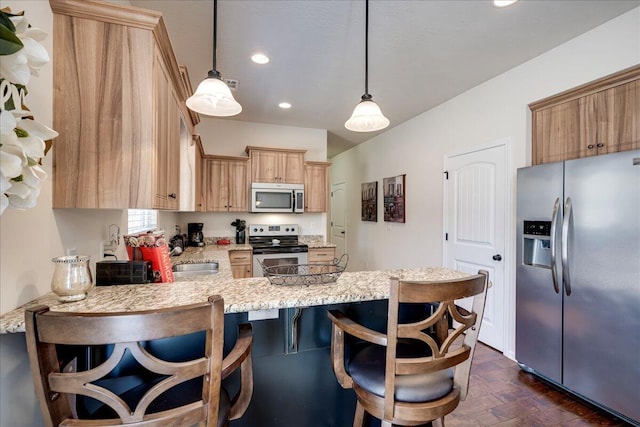 kitchen with pendant lighting, a kitchen breakfast bar, sink, appliances with stainless steel finishes, and kitchen peninsula