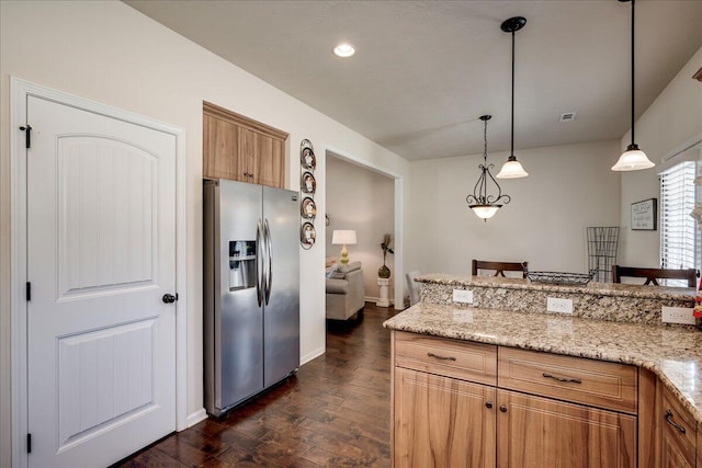 kitchen with decorative light fixtures, stainless steel fridge, light stone counters, and dark hardwood / wood-style floors