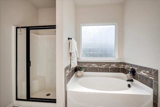 bathroom featuring plenty of natural light and independent shower and bath