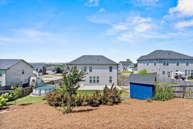 1717 Ethan Way, Hephzibah, GA 30815 - back of house featuring a residential view, a storage shed, and a fenced backyard